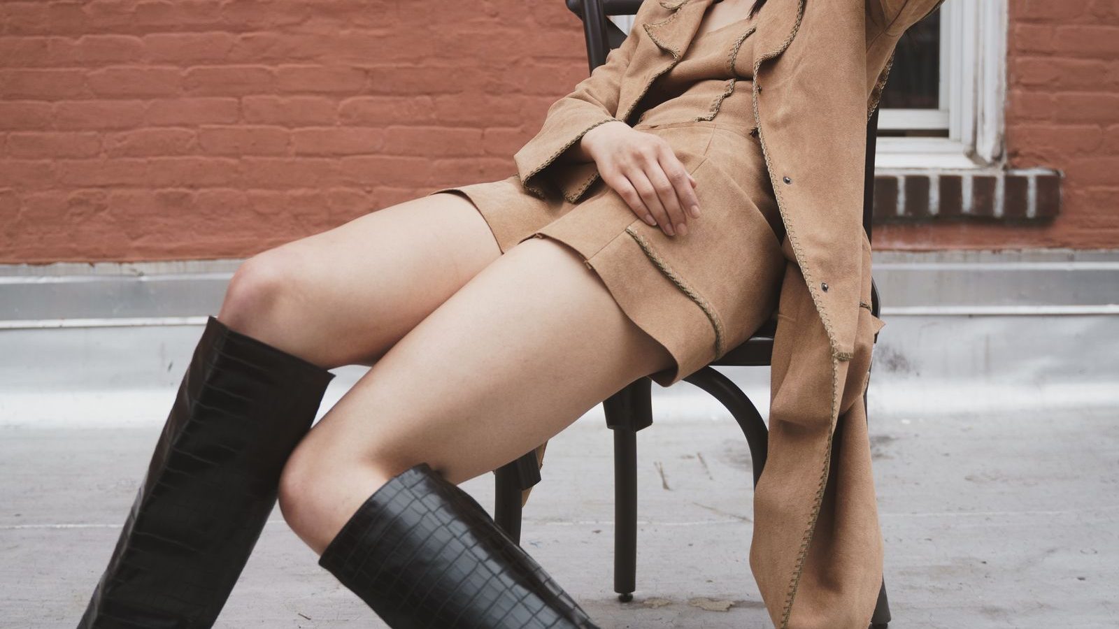 Žena vo vysokých kožených čižmách a kabáte – jesenný street style
