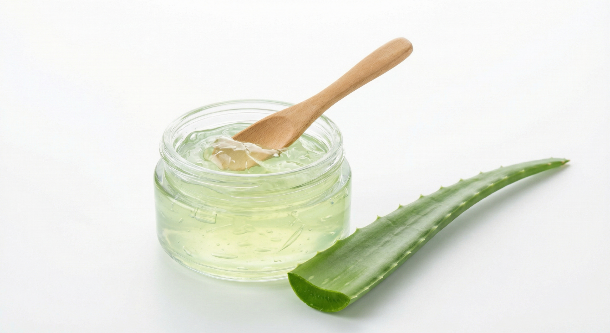 Najlepší aloe vera gél a krém na tvár a telo v roku 2026 2 Čistý aloe vera gél v sklenenej nádobe s drevenou lyžicou